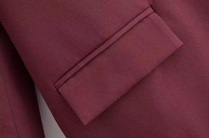Vue détaillée de la poche et de la texture du tissu tissé sur un manteau bordeaux