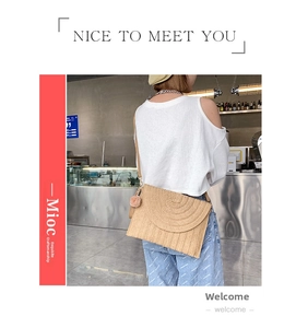Detailed texture of handmade straw crossbody bag featuring pink pompom and woven pattern