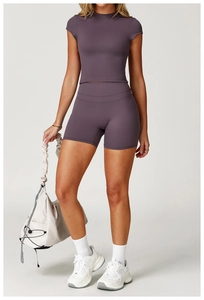 Dettaglio del set yoga viola scuro con top a compressione e pantaloncini da ciclista a vita alta