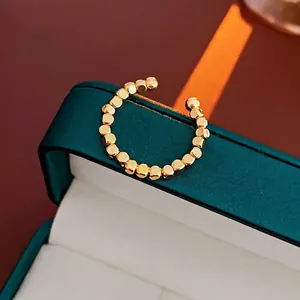Minimalist gold-plated open ring featuring a geometric beaded cube design on a jewelry box