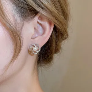 Elegant gold flower pearl earrings with sparkling crystal pavé on female model