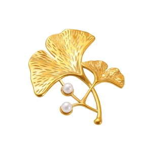 Detailed view of golden ginkgo leaf brooch with fine veins and two white pearls