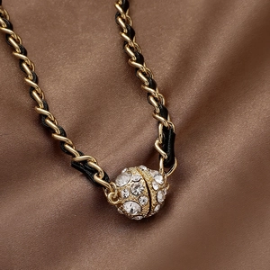Elegant gold magnetic ball clasp with rhinestones on a black leather woven chain