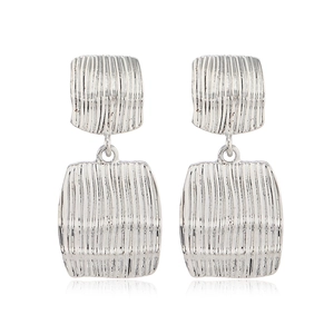 Détail de boucles d'oreilles carrées argentées avec texture martelée et fini métallique