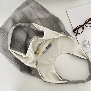 Detail of grey tie-dye denim tote bag interior showing inner pocket and canvas lining