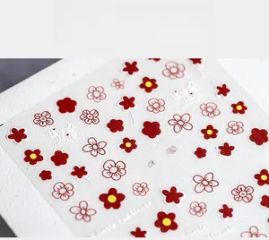 Detailed close-up of 5D embossed nail stickers with red and white floral patterns