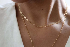 Détail de l'ensemble de colliers superposés en or avec chaîne trombone et perles fines
