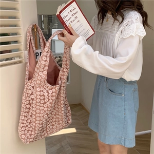 Close-up of floral lace tote bag featuring intricate daisy patterns and a dual-layer design