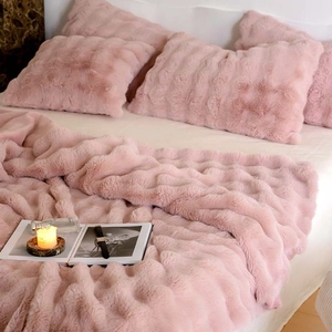 Close-up of soft pink faux fur blanket texture with cozy bedroom decor accessories