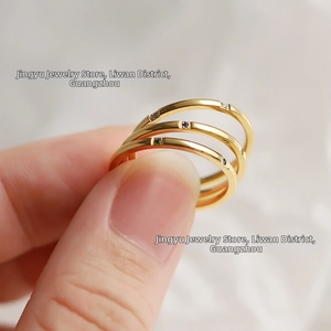 Macro shot of three stacked rings in 18K gold plated titanium with colorful crystals