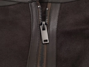 Macro shot of durable metal zipper and brown suede texture on a reversible jacket