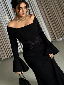 Detail of elegant off-shoulder evening dress featuring flared sleeves and waist pleats