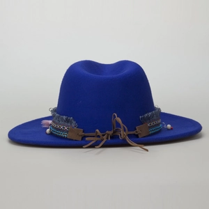 Detail of dark blue fedora with ethnic woven band, tassels and brown leather cord accents