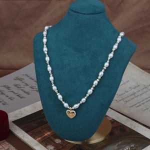 Elegant natural freshwater pearl necklace with a gold heart pendant on velvet display
