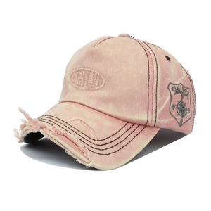 Detail of distressed pink denim cap with Castle embroidery and frayed brim texture
