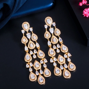Close-up of gold dangle earrings with layered pear-cut white cubic zirconia stones