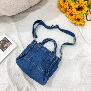 Detail showing vintage washed blue denim fabric with yellow contrast stitching and metal buckle