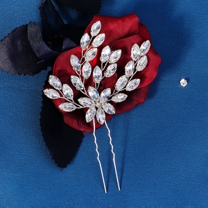 Silver bridal hair pin with marquise rhinestones on a dark floral background