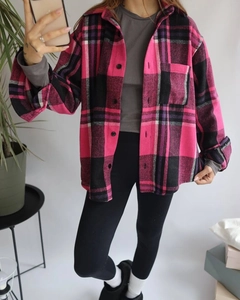 Detail of pink and black plaid flannel shirt with dual chest pockets and button closure