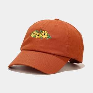 Close-up of intricate sunflower embroidery and cotton fabric texture on baseball cap
