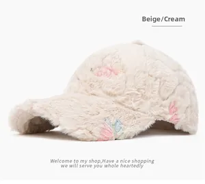 Detailed macro view of the cream plush baseball cap with flower and butterfly embroidery