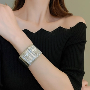 Detail of wide silver twist bracelet with layered wire texture on model wrist