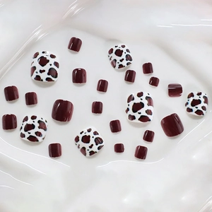Square press-on toe nails in burgundy and leopard print set on a white wavy background