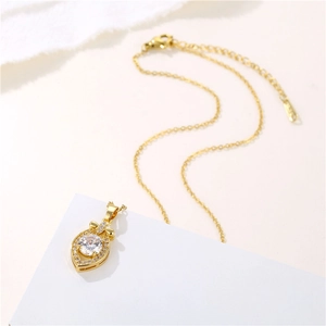 Golden stainless steel necklace with waterdrop zircon pendant on a white pedestal