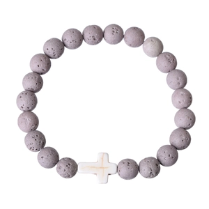 Close-up of natural grey volcanic stone beads and a white cross bead on an elastic bracelet