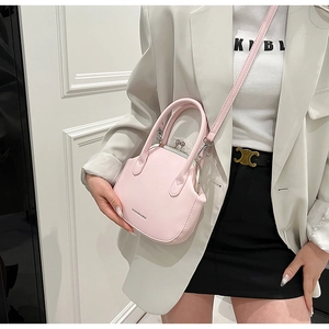 Detail of pink shell bag featuring vintage metal clasp and embossed fashion lettering