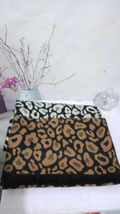 Folded leopard print scarves in black white and brown colors with soft fringe detail