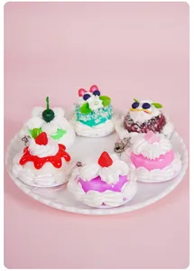 Detailed view of six miniature realistic cream cake keychains with strawberry and cherry toppings