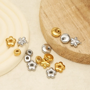 Gold- und Silberanhänger in Blumen- und Rundform auf minimalistischem Hintergrund