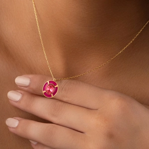 Elegant gold pendant necklace with pink zircon gemstone worn by a model on neck