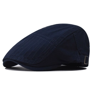 Detail of navy blue newsboy cap featuring a side metal buckle and contrast stitching