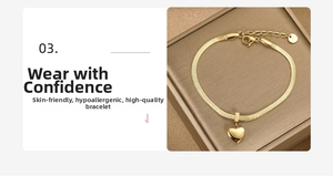 Detail of gold snake chain bracelet featuring heart pendant and stainless steel engraving