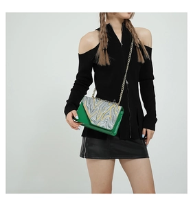 Detailed shot of green and marble PU leather crossbody bag with golden chain strap