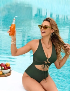 Detail of dark green cutout swimsuit featuring a plunging V-neck and waist tie design