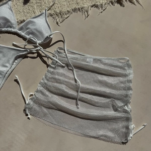 Détail de la texture mesh argenté métallique sur le bikini trois pièces et la jupe