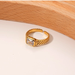 Detail of 18k gold plated ring with rectangular white zircon and textured wide band