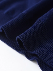 Vue macro d'un tricot bleu marine avec poignet côtelé élastique et texture