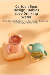 Close-up of baby sippy cups with bear-shaped lids and double handles in pink and green