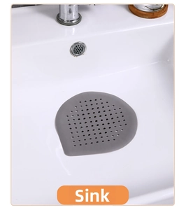 Macro del filtro copri scarico in silicone grigio posizionato in un lavabo bianco