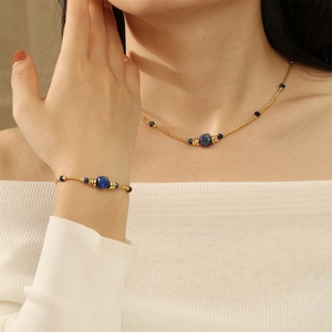 Detail of blue sodalite beaded necklace and matching gold bracelet on model