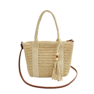 Woven straw tote bag in beige with brown leather strap and decorative tassel