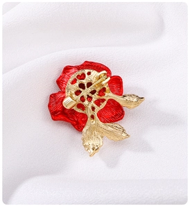 Macro detail of the gold-plated pin clasp on the back of the red rose brooch