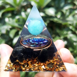Handheld Orgonite energy pyramid with blue crystal ball and copper coil detail