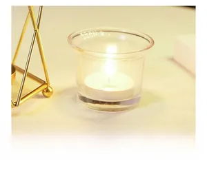 Close-up of thick heat-resistant glass candle holder with a lit white candle inside