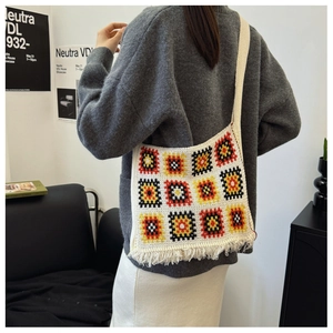Detail of crochet tote bag with colorful squares and decorative bottom tassels
