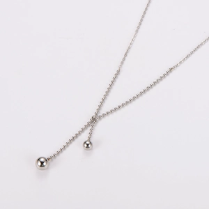 Detailed view of minimalist silver bead chain necklace featuring two large sphere pendants